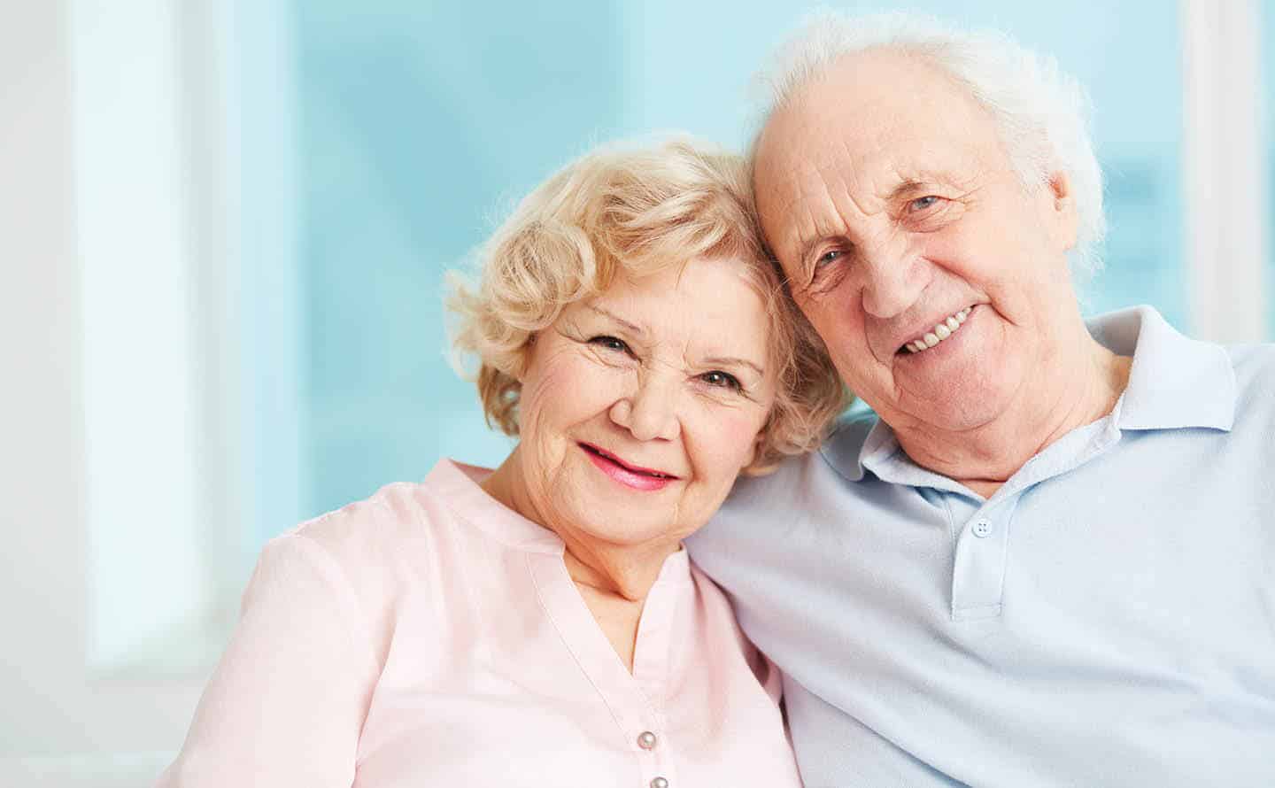 elderly couple posing and smiling for the camera