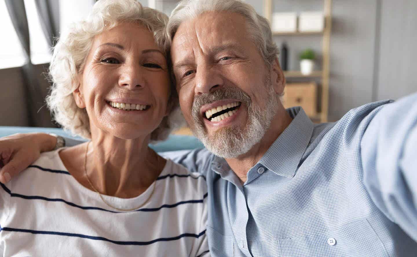 elderly couple smiling and taking a selfie