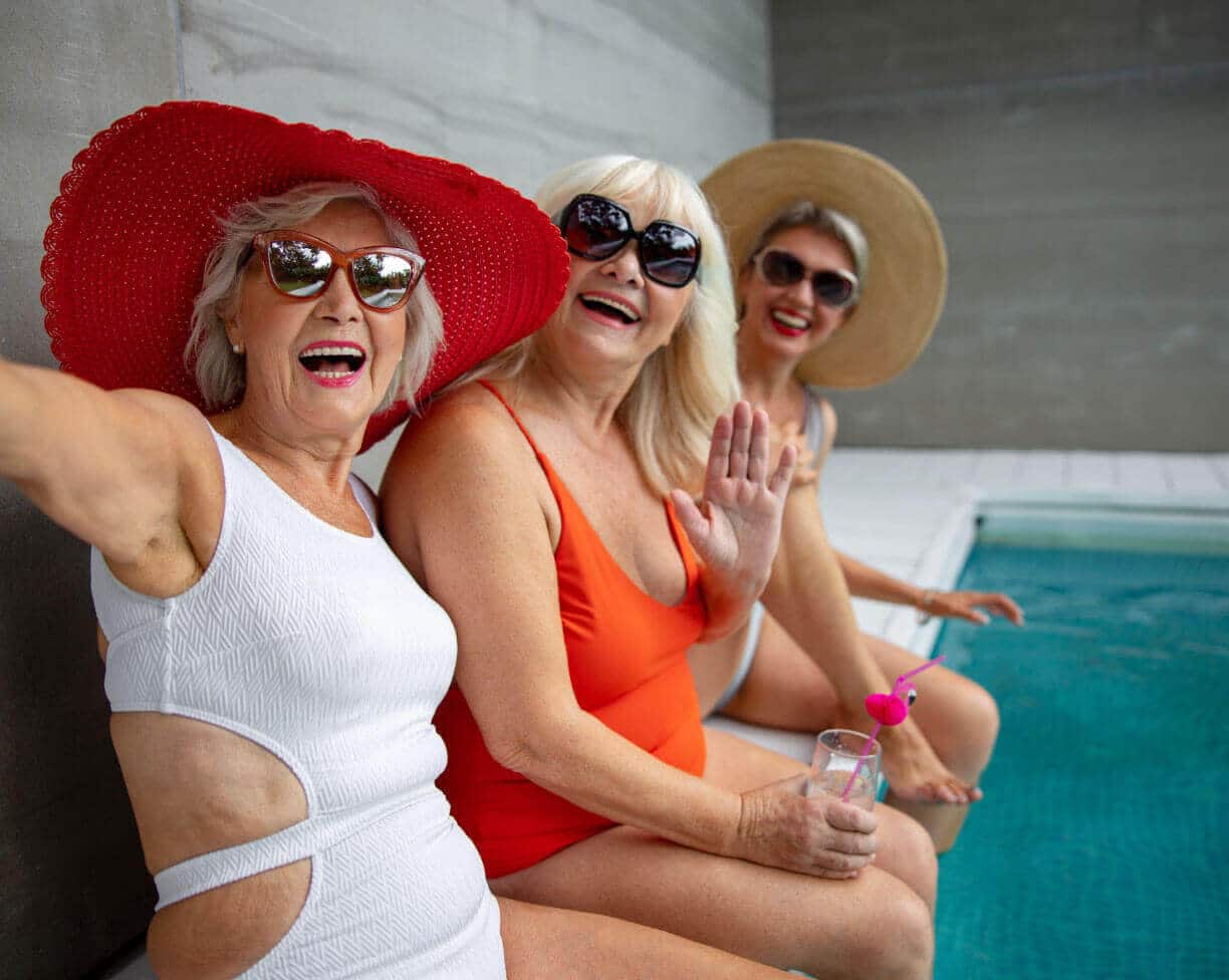 three women in swimsuits by the pool
