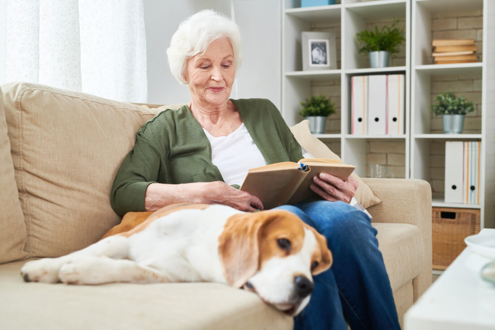 woman reading with her dog on a couch