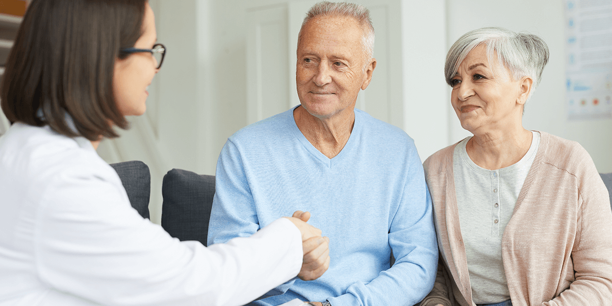 Doctor shaking hands with elderly seniors.